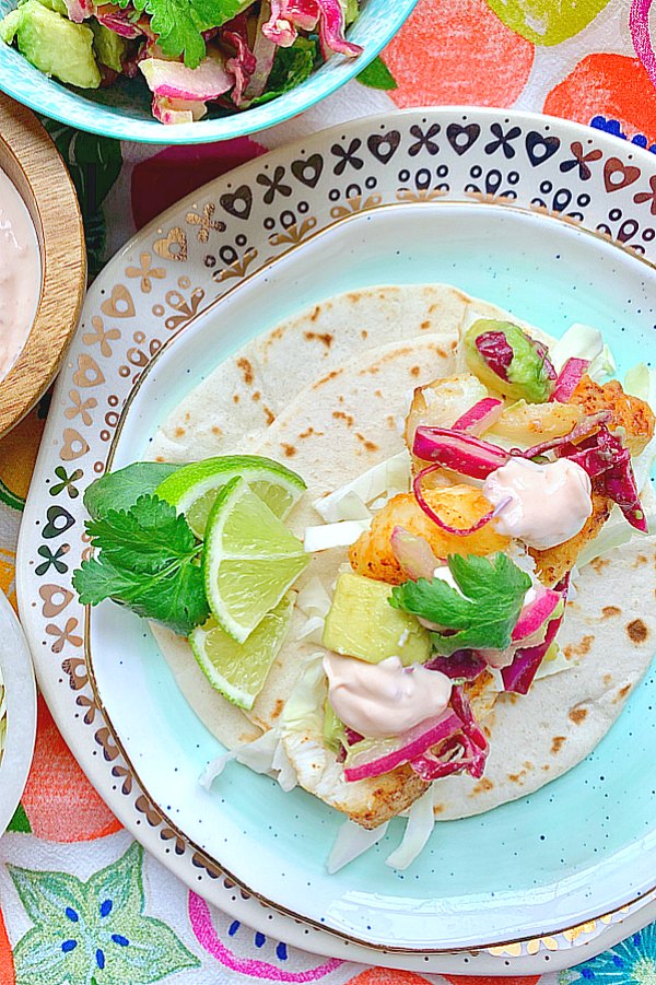 overhead view of open face fish taco garnished with lime