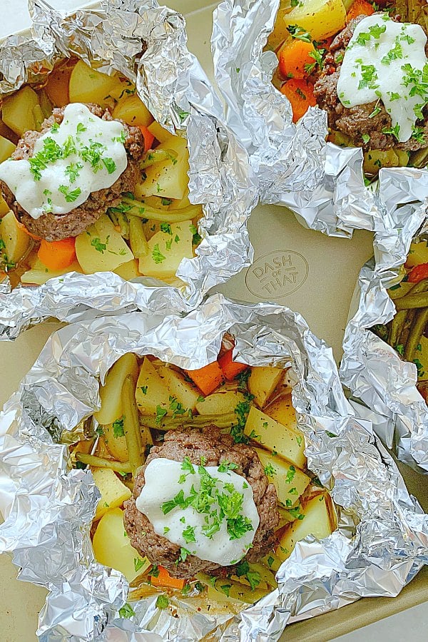 cooked hobo dinner foil packets on a baking sheet