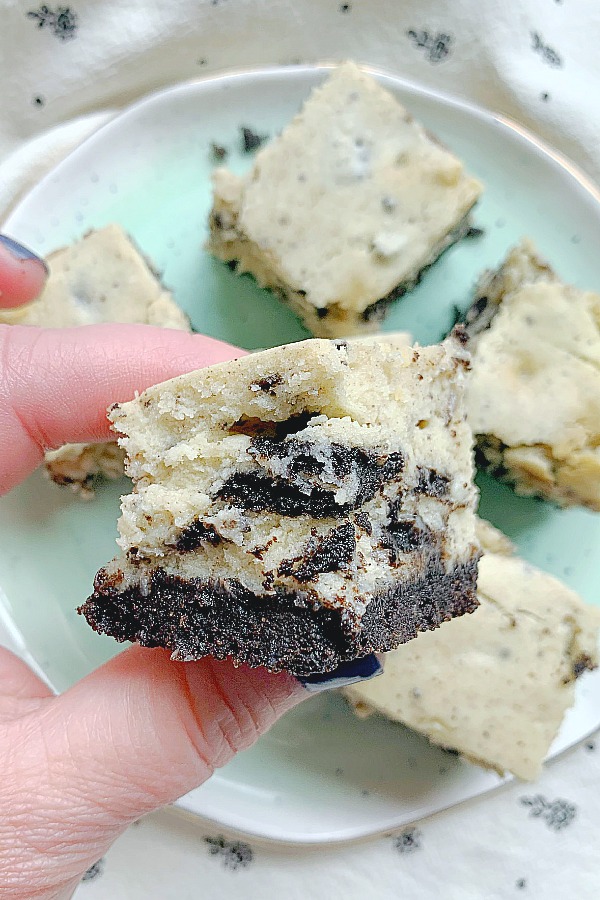 holding a square of oreo cheesecake