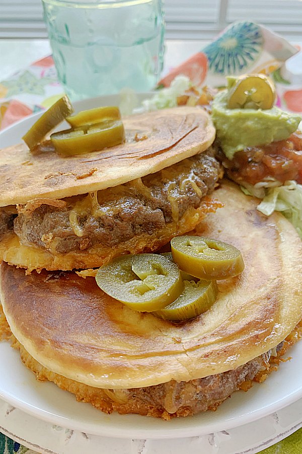 close of quesadilla burger topped with jalapeño peppers