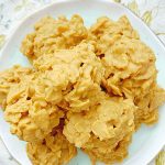 peanut butter cornflake cookies piled on a plate