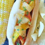 loaded air fryer brat on a plate with corn on the cob and potato chips