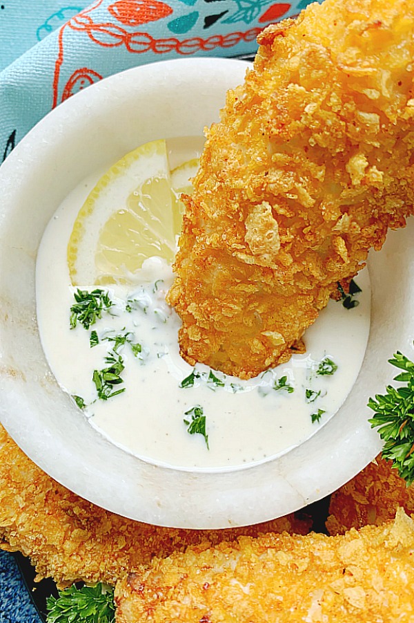 dipping an air fryer chicken tender into ranch dressing