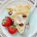 a slice of chocolate chip cake on a plate with a fork