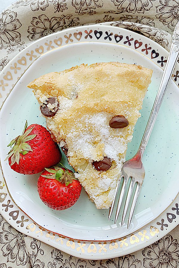 a slice of chocolate chip cake on a plate with a fork