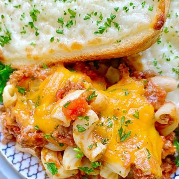 johnny marzetti on a plate with garlic bread slices