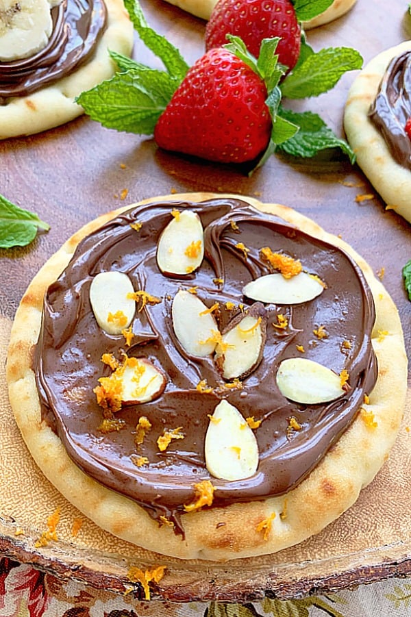 nutella pizza topped with sliced almonds and orange zest