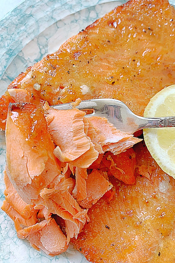 cooked salmon being flaked with a fork