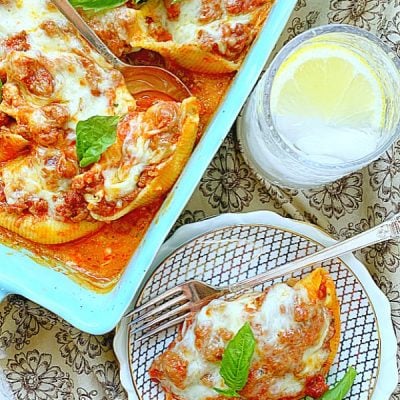 casserole dish and plate full of conchiglioni pasta stuffed shells with meat sauce