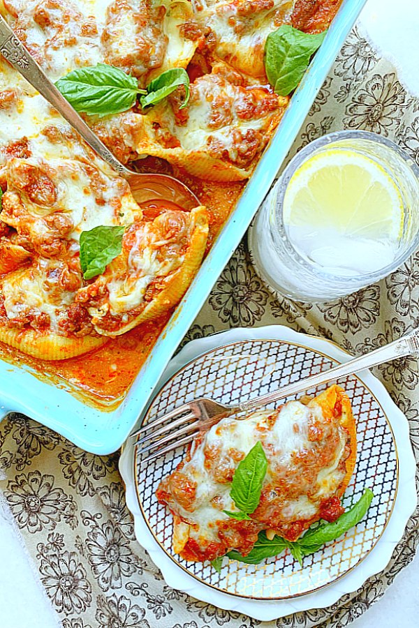 casserole dish and plate full of conchiglioni pasta stuffed shells with meat sauce