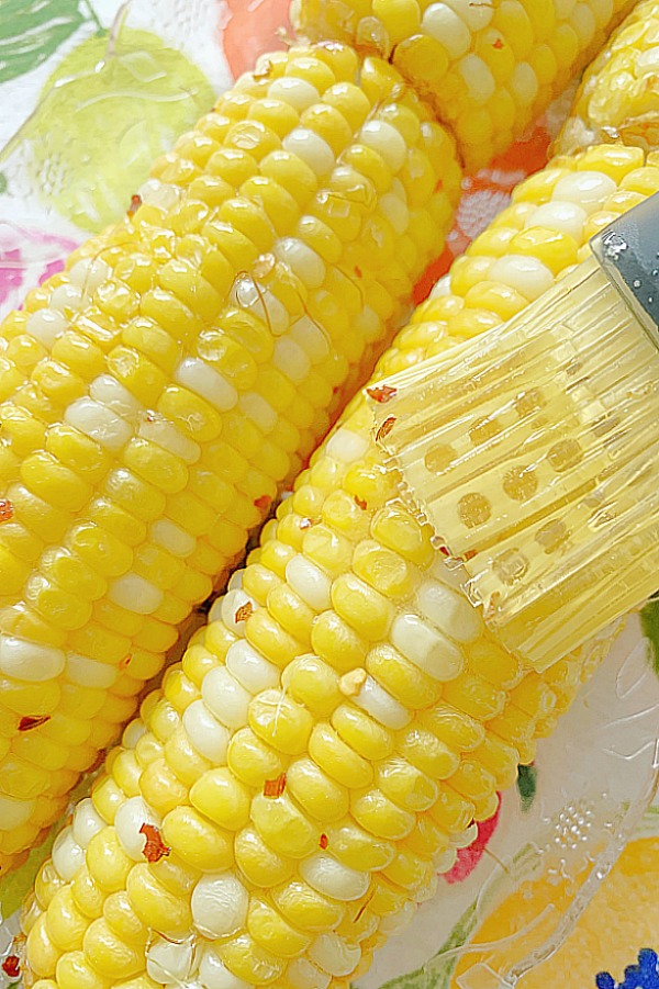 brushing the air fryer corn on the cob with honey butter