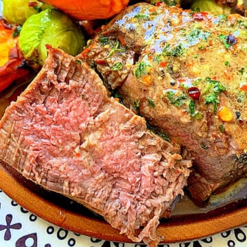 sliced air fryer filet mignon plated with brussels sprouts and sweet potatoes