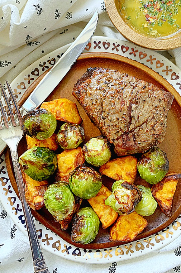 filet mignon on plate with air fried Brussels sprouts and sweet potatoes