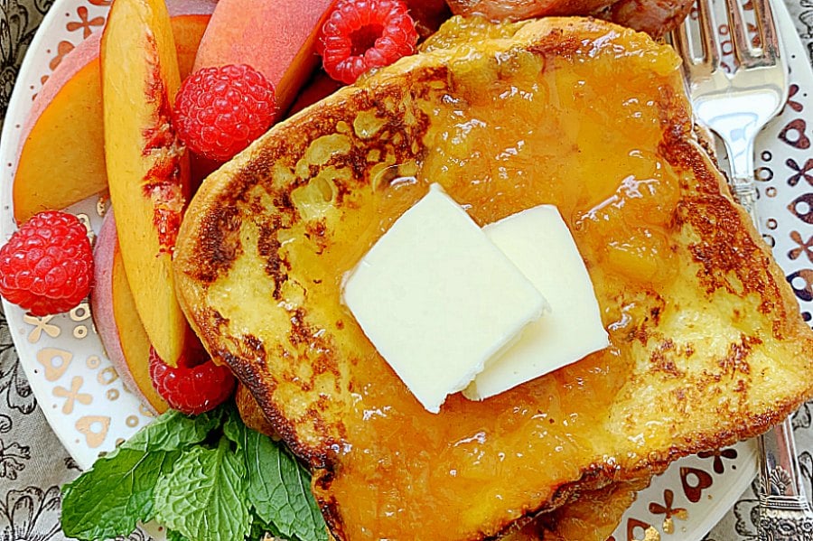 buttermilk french toast topped with peach syrup and butter