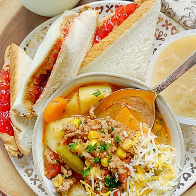 campfire stew in a bowl with peanut butter and jell sandwich on the side