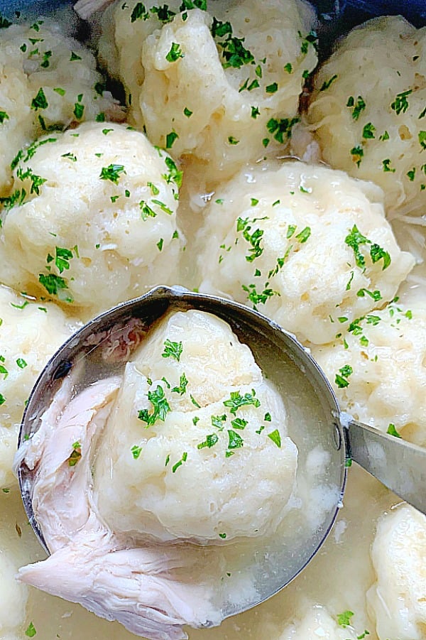 southern chicken and dumplings being served with a ladle