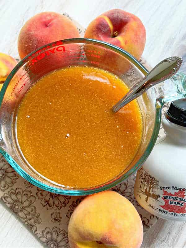 three cups of freshly made peach syrup in a glass pyrex measuring cup