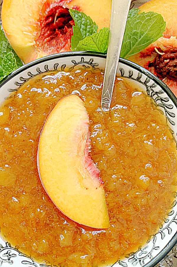 peach syrup in a bowl with a fresh peach slice on top