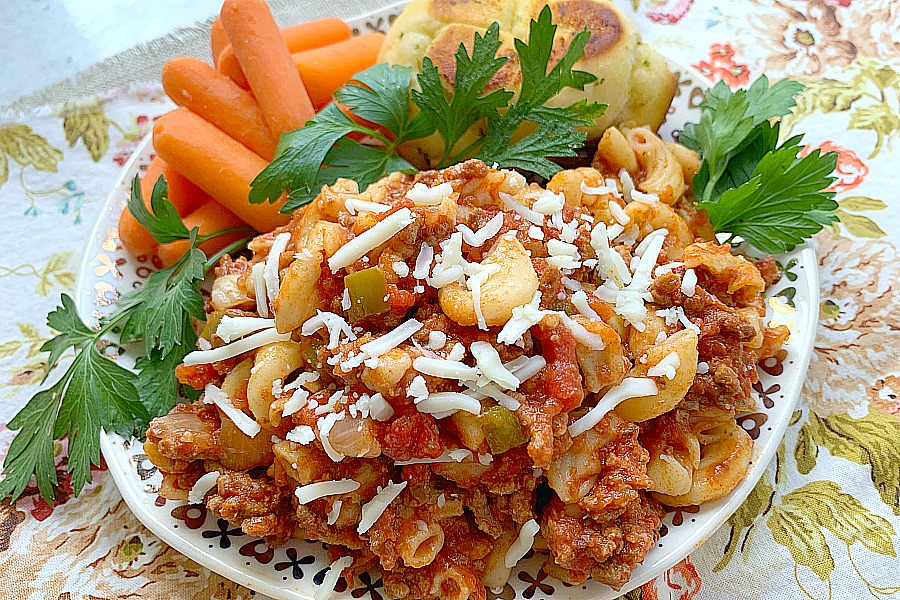 beef goulash on a plate with carrots and bread