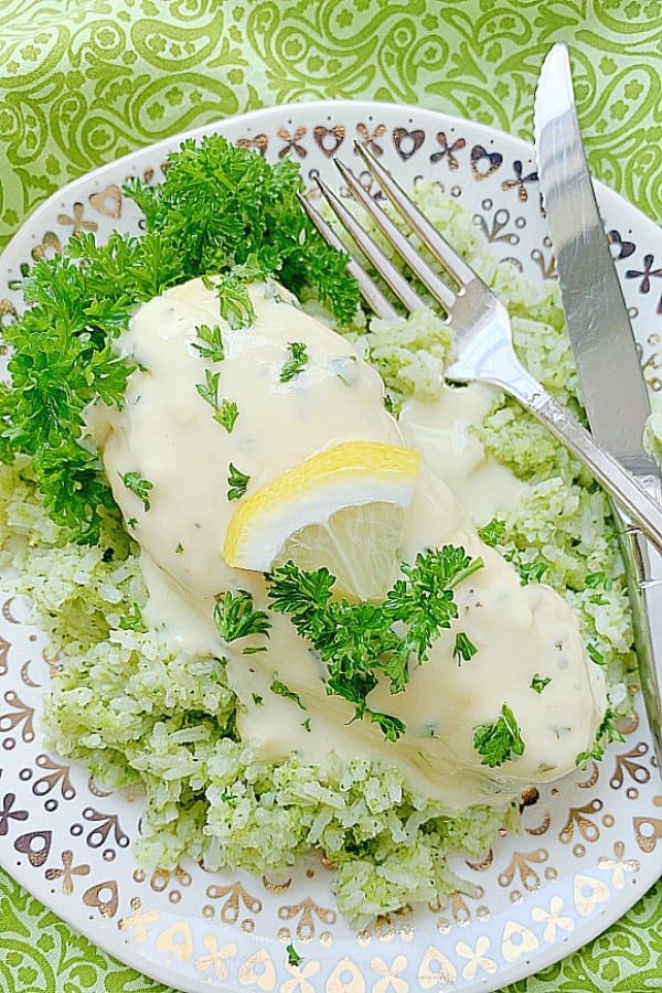 lemon chicken on a plate with broccoli rice and creamy sauce