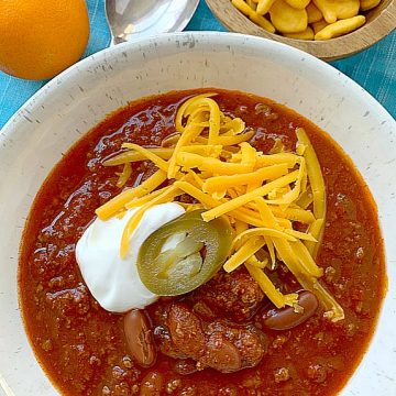 chili in a bowl topped with cheese and sour cream