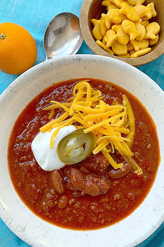chili in a bowl topped with cheese and sour cream