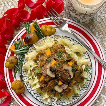 chestnut beef stew on a plate with egg noodles