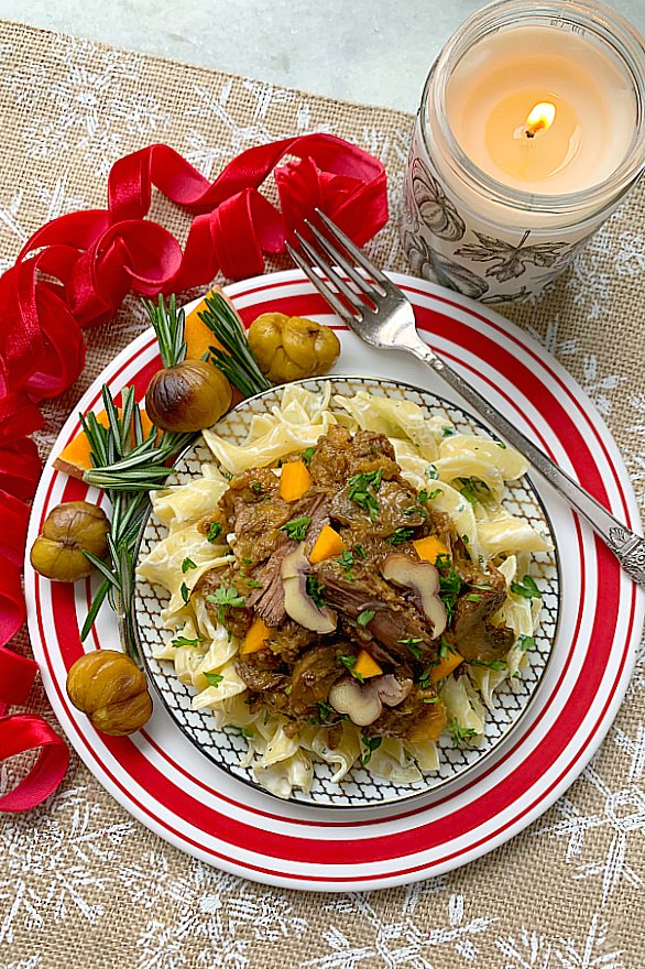 chestnut beef stew on a plate with egg noodles