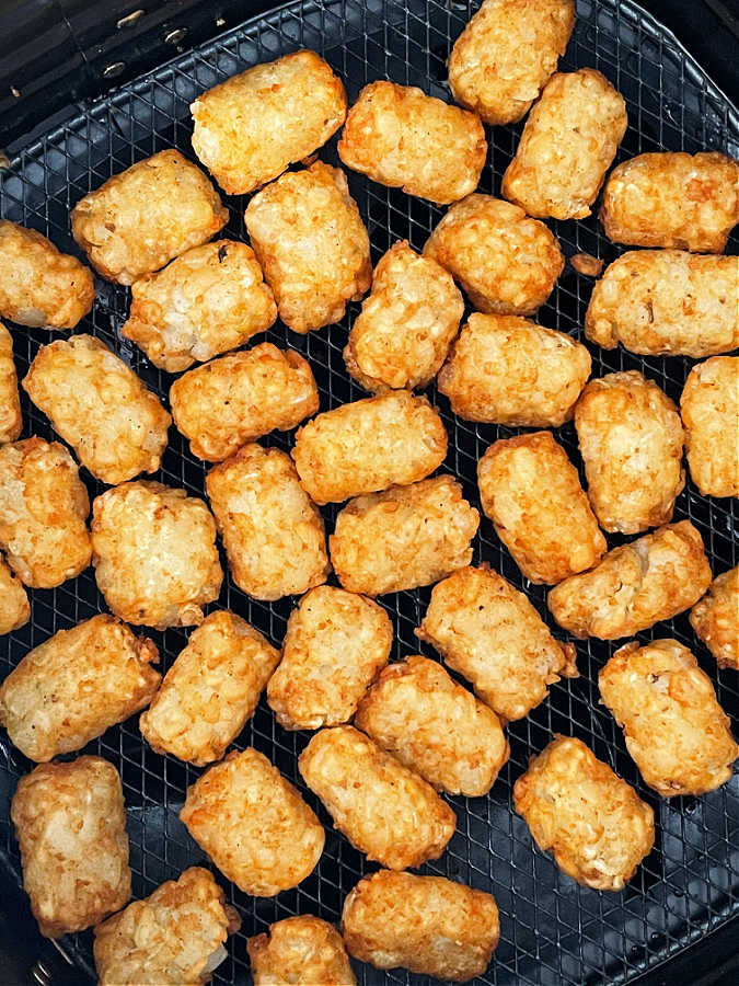 tater tots in the basket of an air fryer