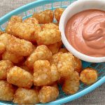 air fryer tater tots in a basket with fry sauce on the side