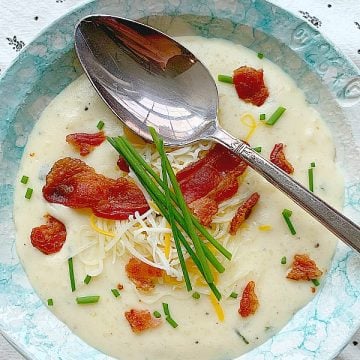a bowl of easy baked potato soup topped with chives and bacon