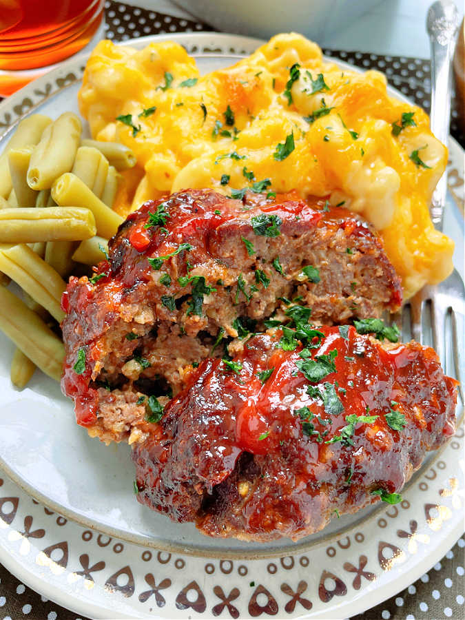 two slices of glazed air fryer meatloaf sprinkled with fresh parsley