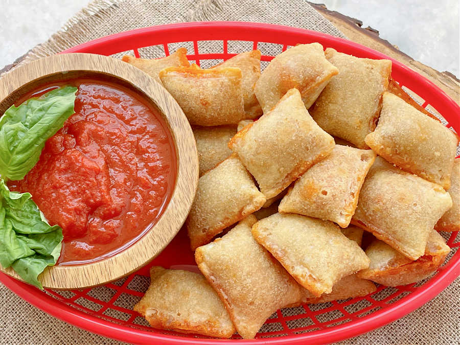 air fryer pizza rolls in a basket with marinara for dipping