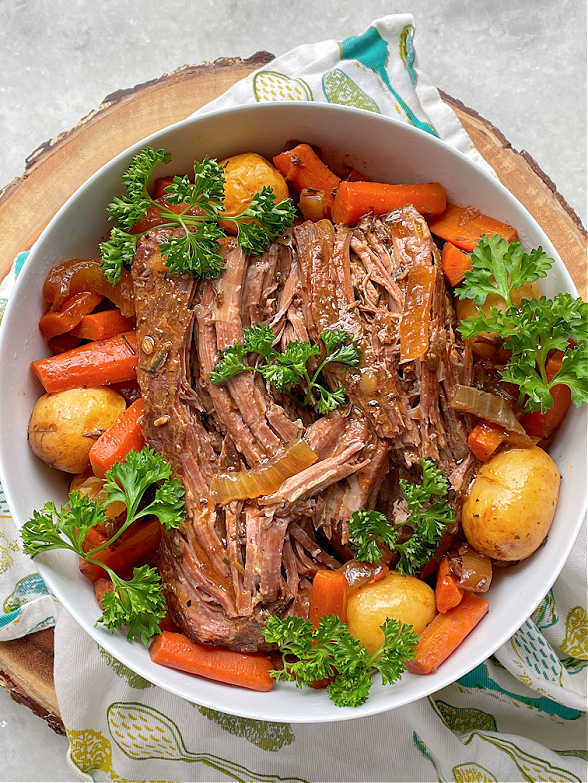 slow sirloin tip roast in a bowl with potatoes and carrots