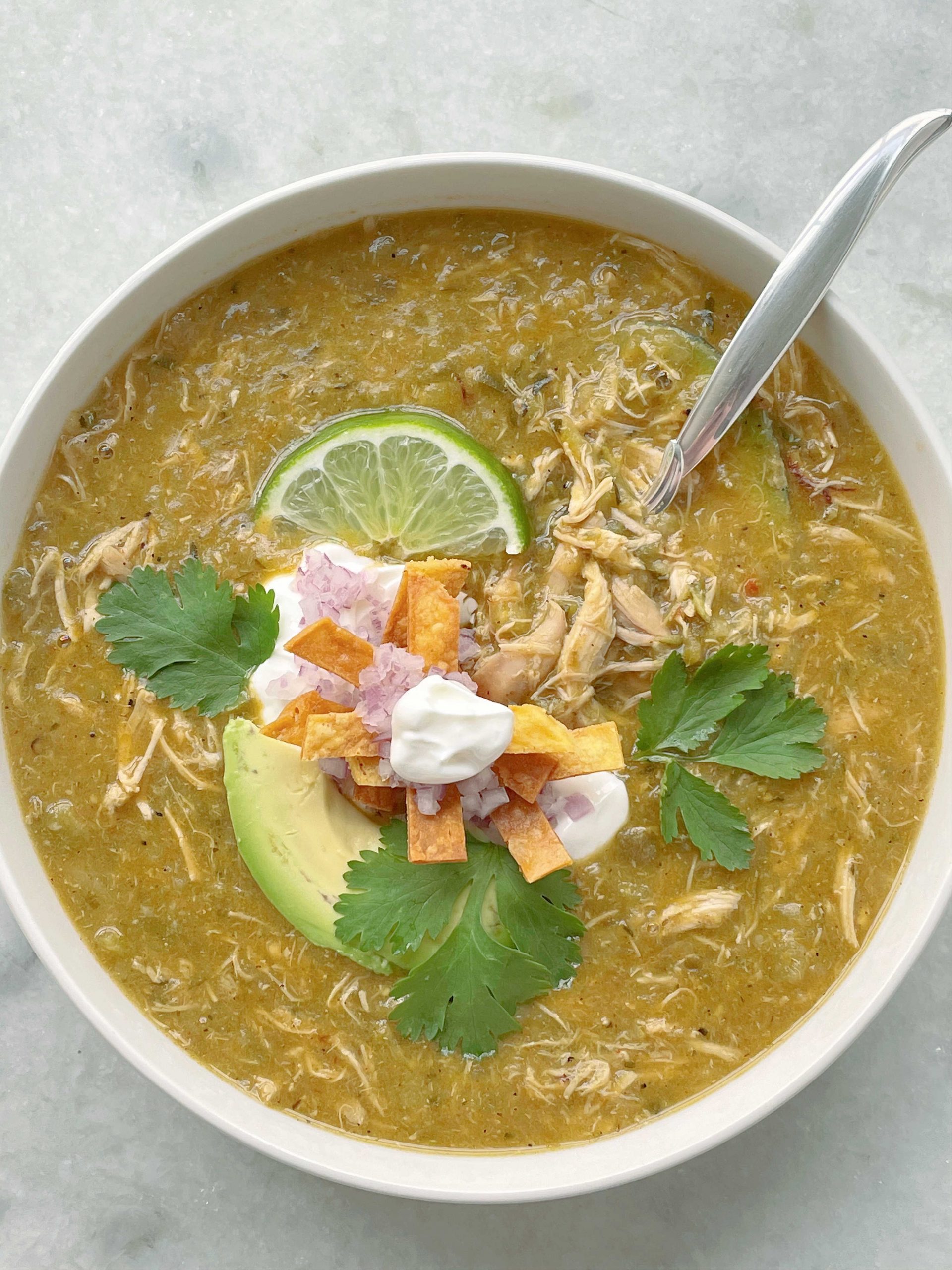 a bowl full of green chicken enchilada soup