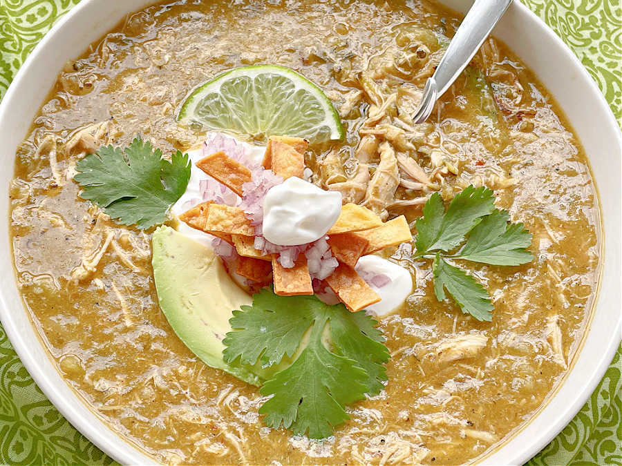 horizontal crop of chicken soup in a bowl topped with avocado