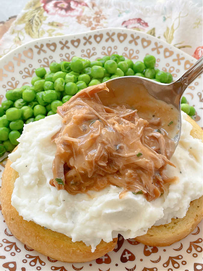 ladling the beef gravy on top of the mashed potatoes