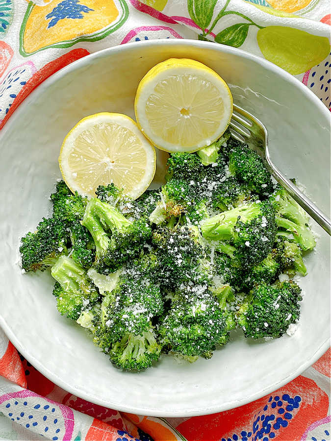 air fryer broccoli in a bowl with lemon halves