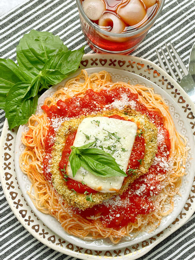 air fryer chicken parmesan on a plate of angel hair pasta