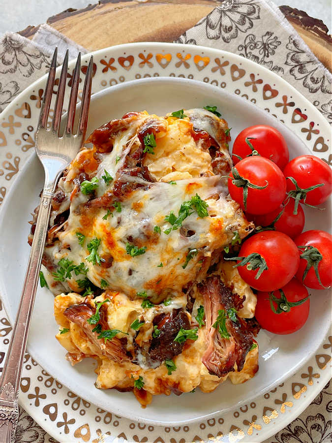 bbq mac and cheese on a plate with cherry tomatoes on the side