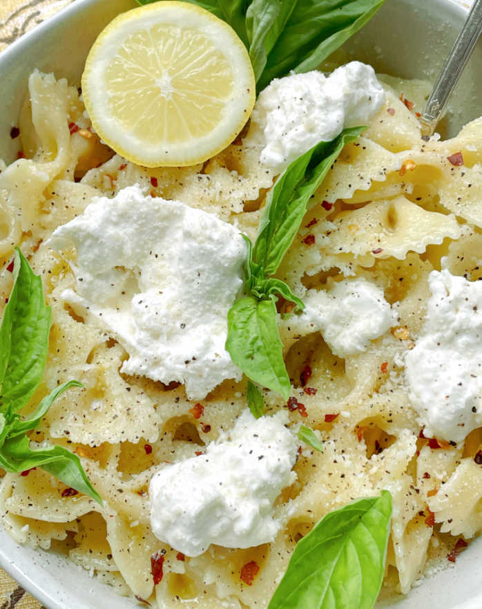 pasta topped with burrata cheese and fresh basil