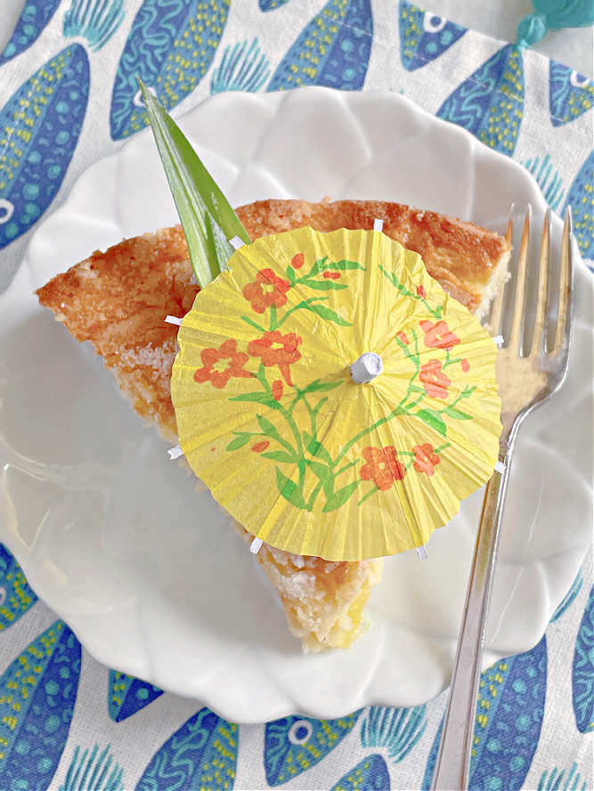 view from the top - a slice of pineapple cake topped with a cocktail umbrella