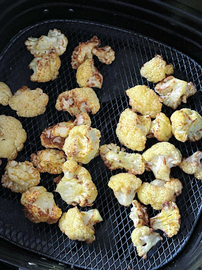 cooked cauliflower in the basket of the air fryer
