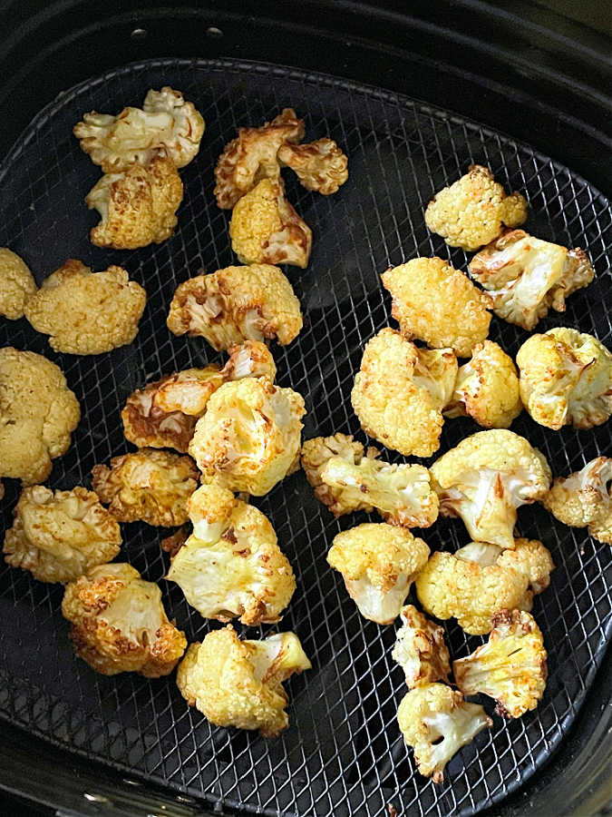 roasted cauliflower florets in the air fryer basket