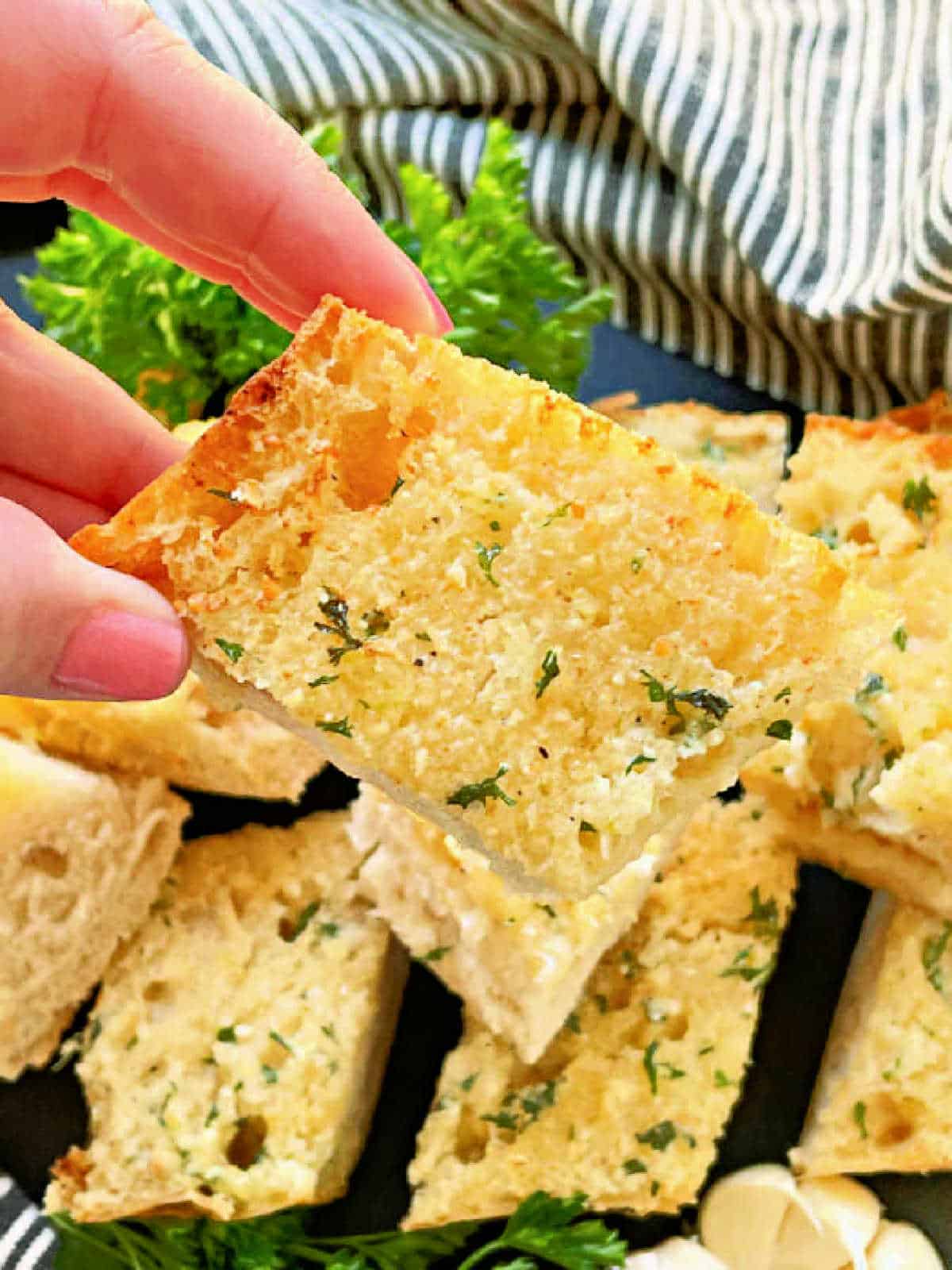 holding a slice of air fryer garlic bread