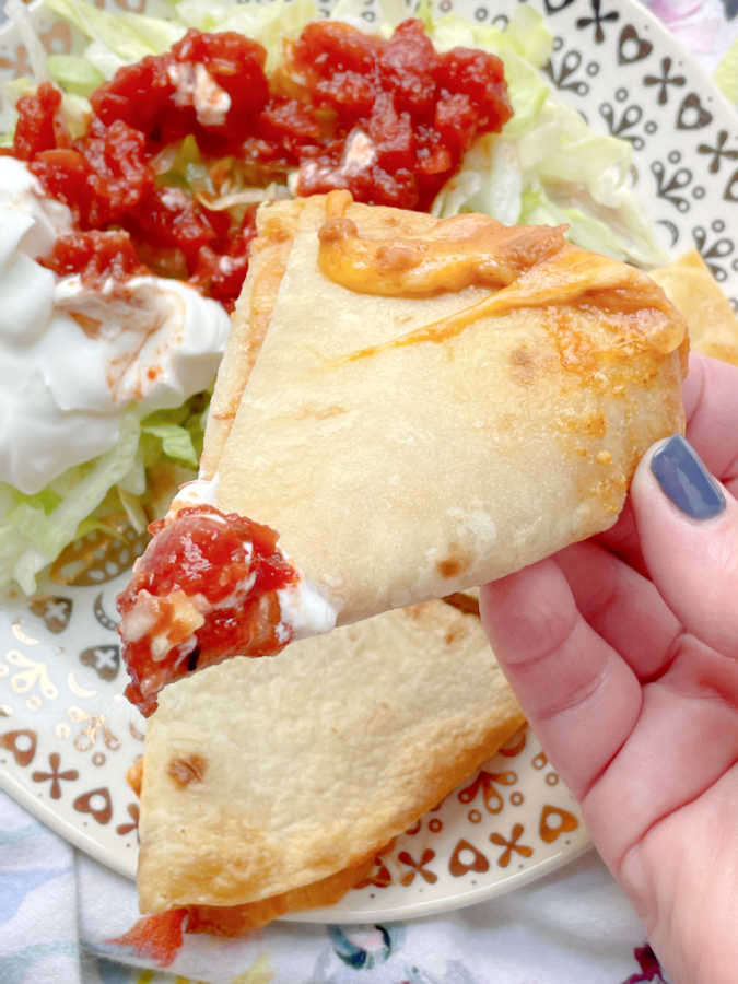 dipping a triangle of air fryer quesadilla into salsa