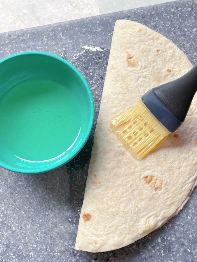brushing the air fryer quesadilla with vegetable oil