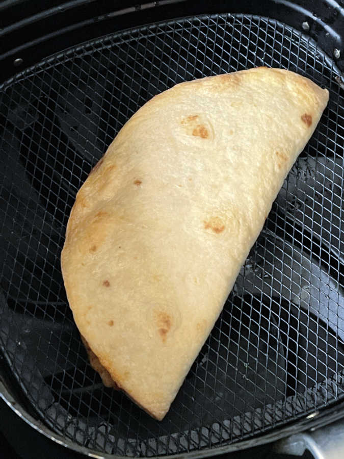 cooked quesadilla in the basket of the air fryer