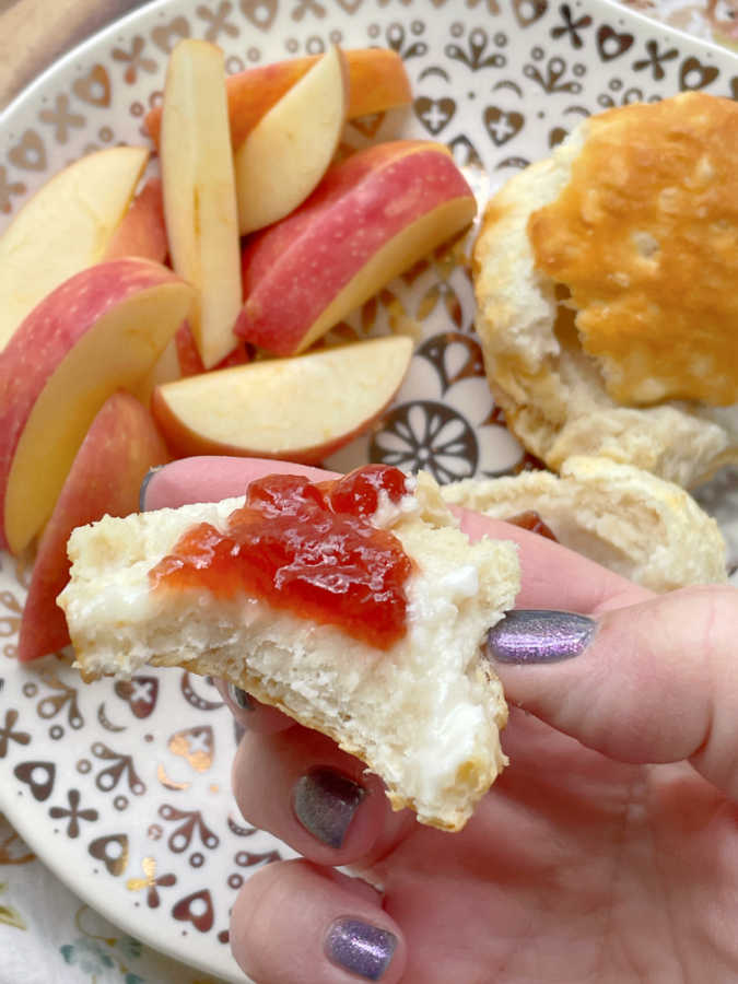 taking a bite of an air fryer frozen biscuit