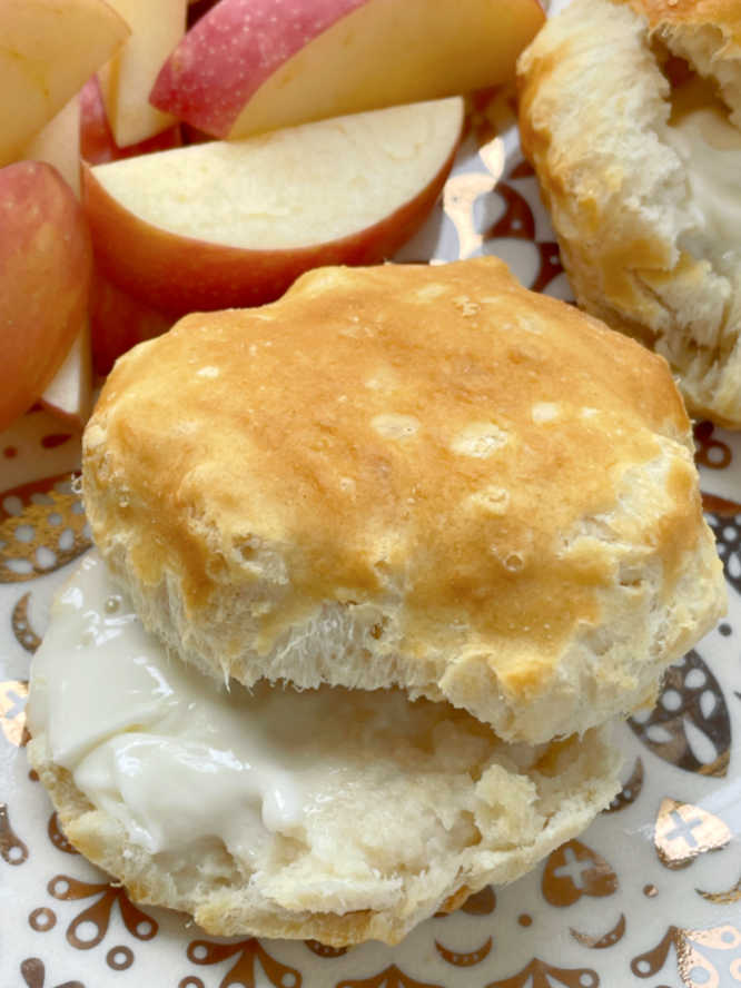 showing a frozen biscuit cooked in the air fryer split and buttered